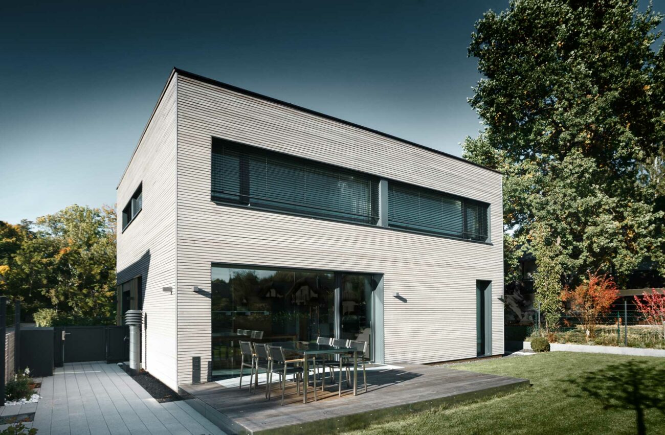 Passivhaus in München - Kubische Bauform mit Flachdach und mit Holz verkleideter Fassade.
