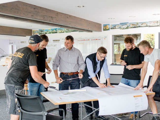 Team-Besprechung über Bauplänen im Büro