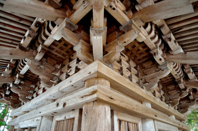 Dachüberstand eines asiatischen Holztempels mit vielen Details zur Erdbebensicherung